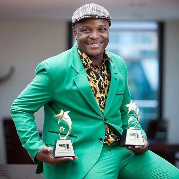 Felix Odiwuor holding awards he won as one of the best Influencers in Kenya.